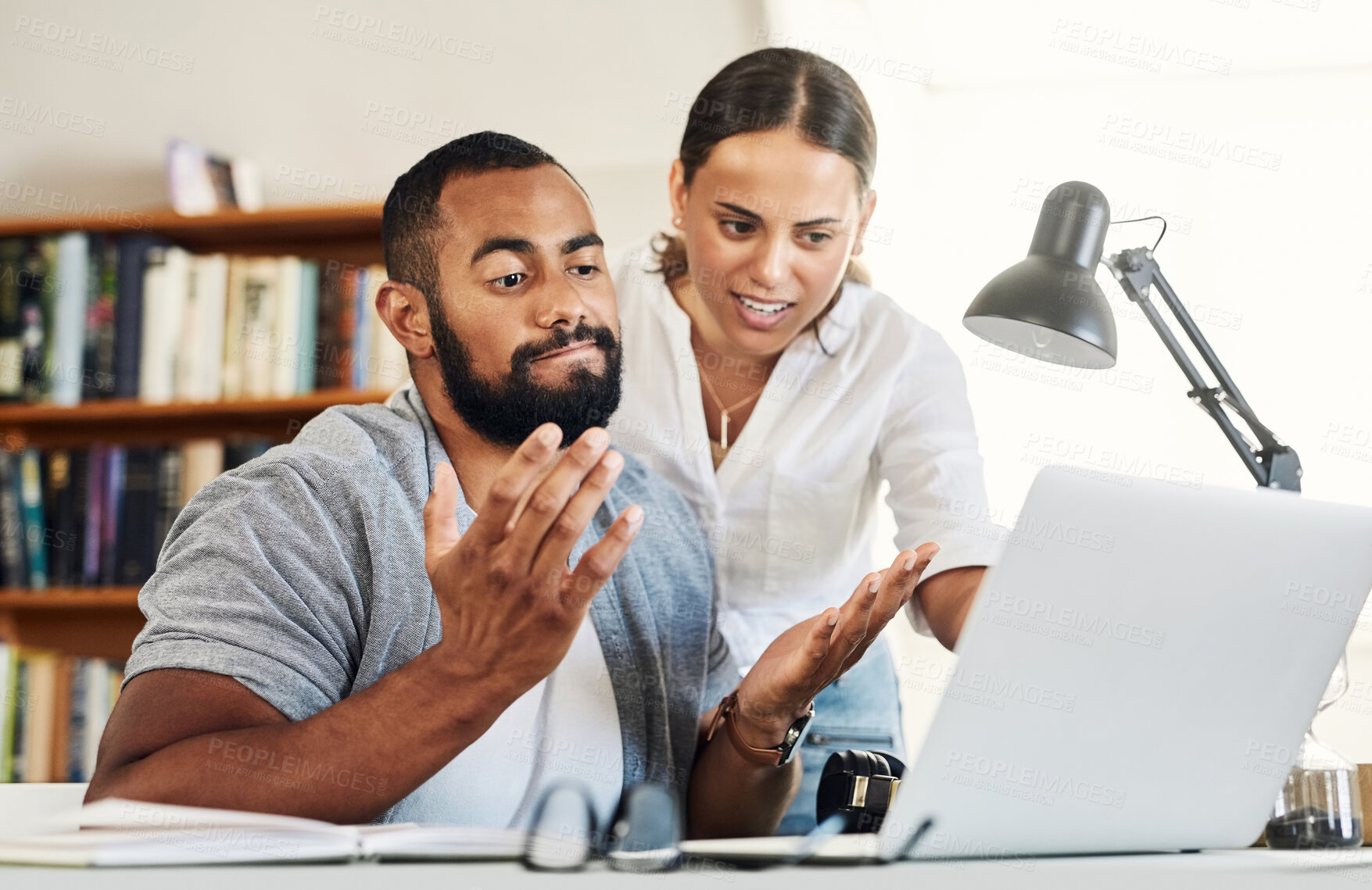 Buy stock photo Shot of a husband and wife talking while he works from home