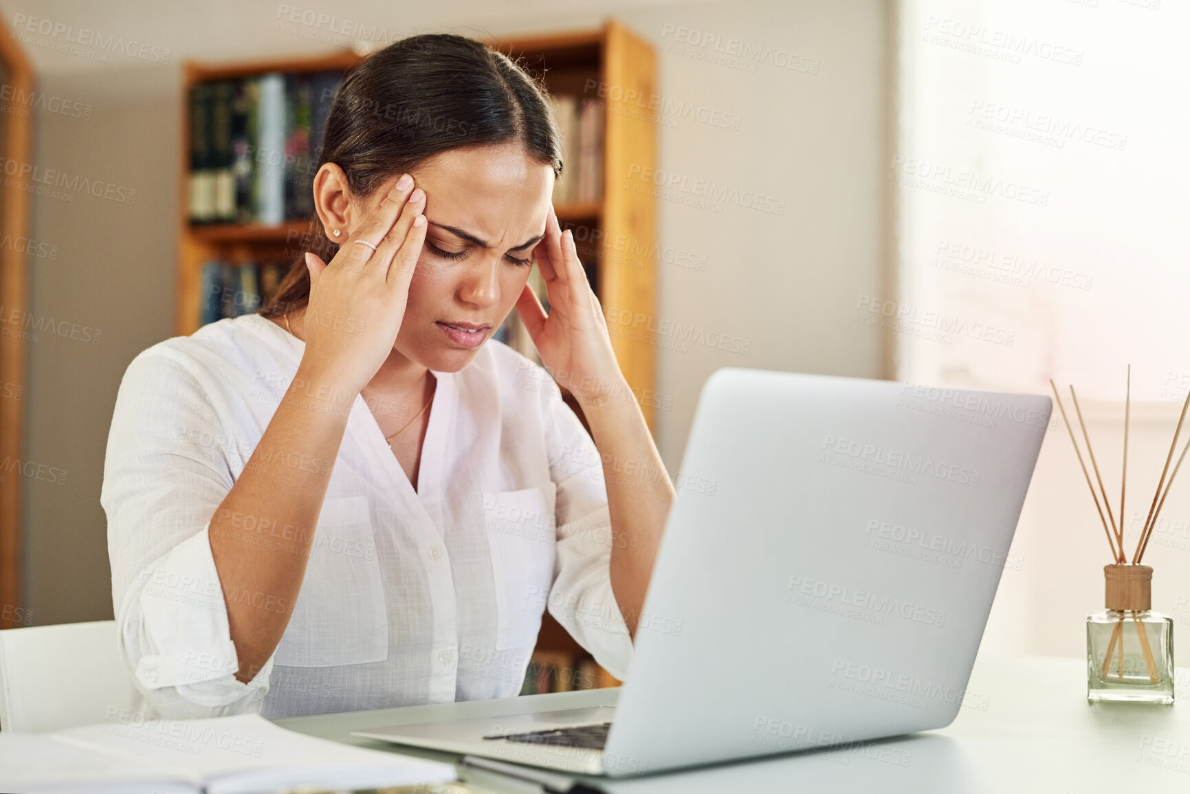 Buy stock photo Shot of a young businesswoman experiencing a headache while working from home