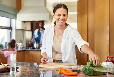 Buy stock photo Shot of a beautiful young woman chopping vegetables at home