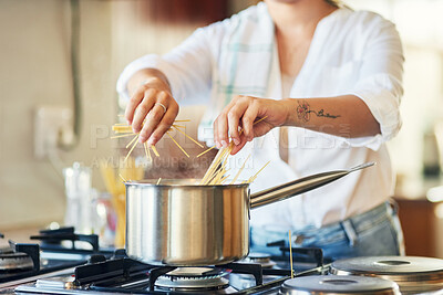 Buy stock photo Shot of a woman breaking spaghetti before boiling it