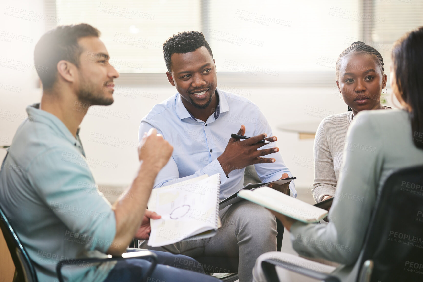 Buy stock photo Cropped shot of a diverse group of businesspeople sitting in the boardroom during a meeting