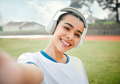 Buy stock photo Cropped portrait of an attractive young female athlete taking selfies while standing outside on a sports field and listening to music