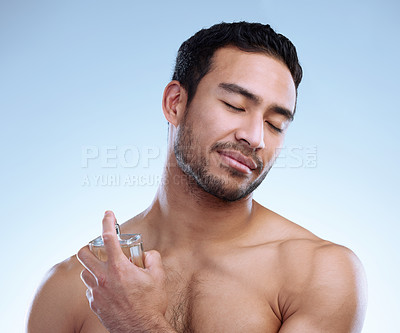 Buy stock photo Man, perfume and spray in studio for wellness, hygiene and calm for self care with zen and smile. Deodorant, scent and male person by white background for cologne, cosmetics and skincare routine