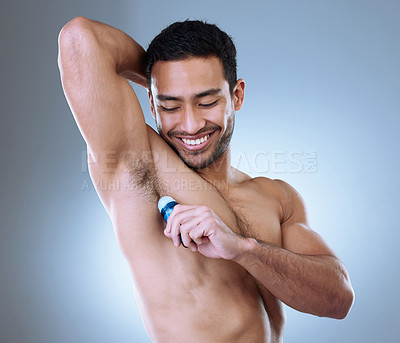 Buy stock photo Studio shot of a handsome young man applying deodorant