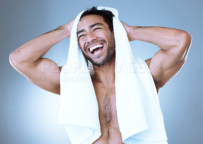 Buy stock photo Studio shot of a handsome young man drying himself with a towel while posing against a grey background