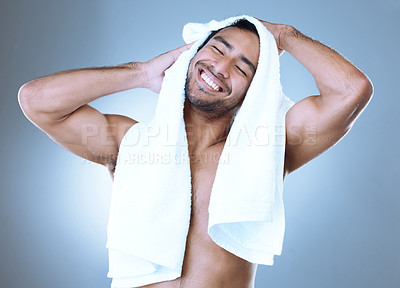 Buy stock photo Studio shot of a handsome young man drying himself with a towel while posing against a grey background