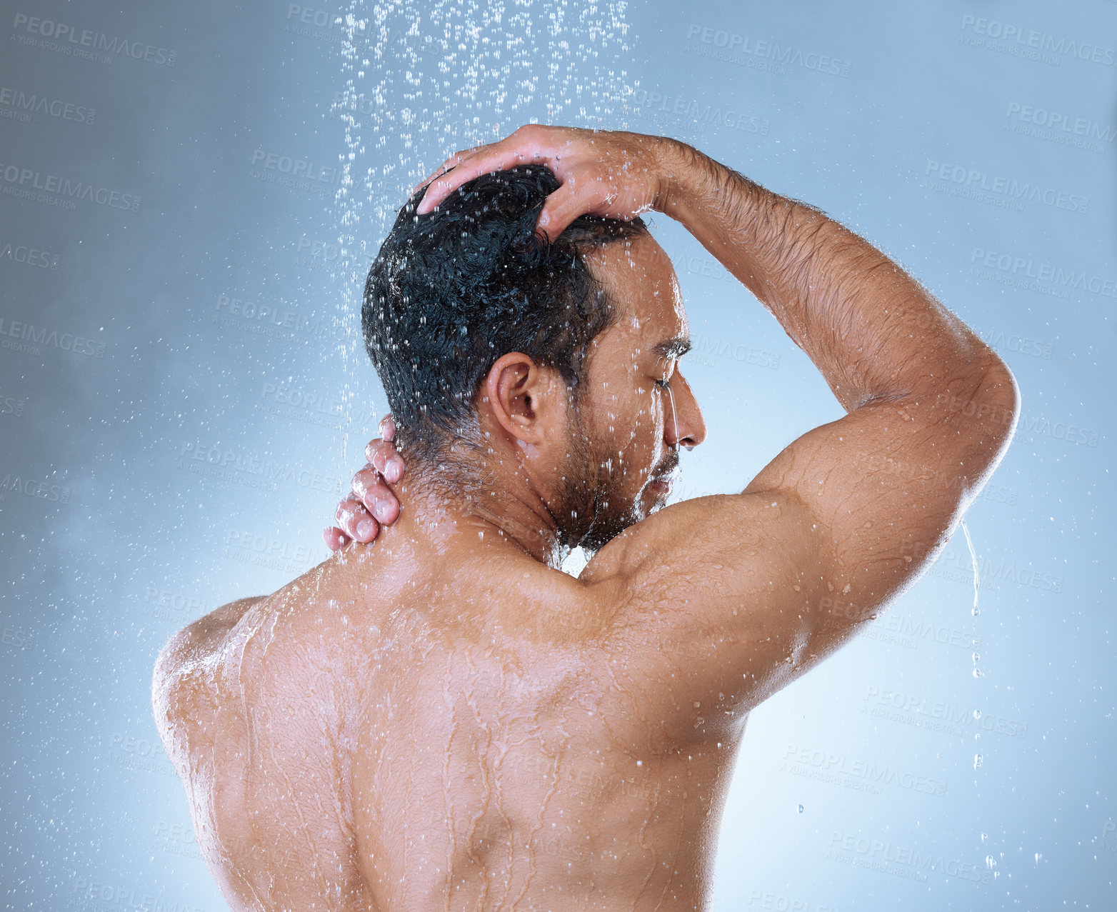Buy stock photo Rearview studio shot of a handsome young man washing his hair in a shower against a grey background