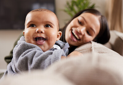 Buy stock photo Shot of a young woman relaxing with her adorable baby on the sofa at home