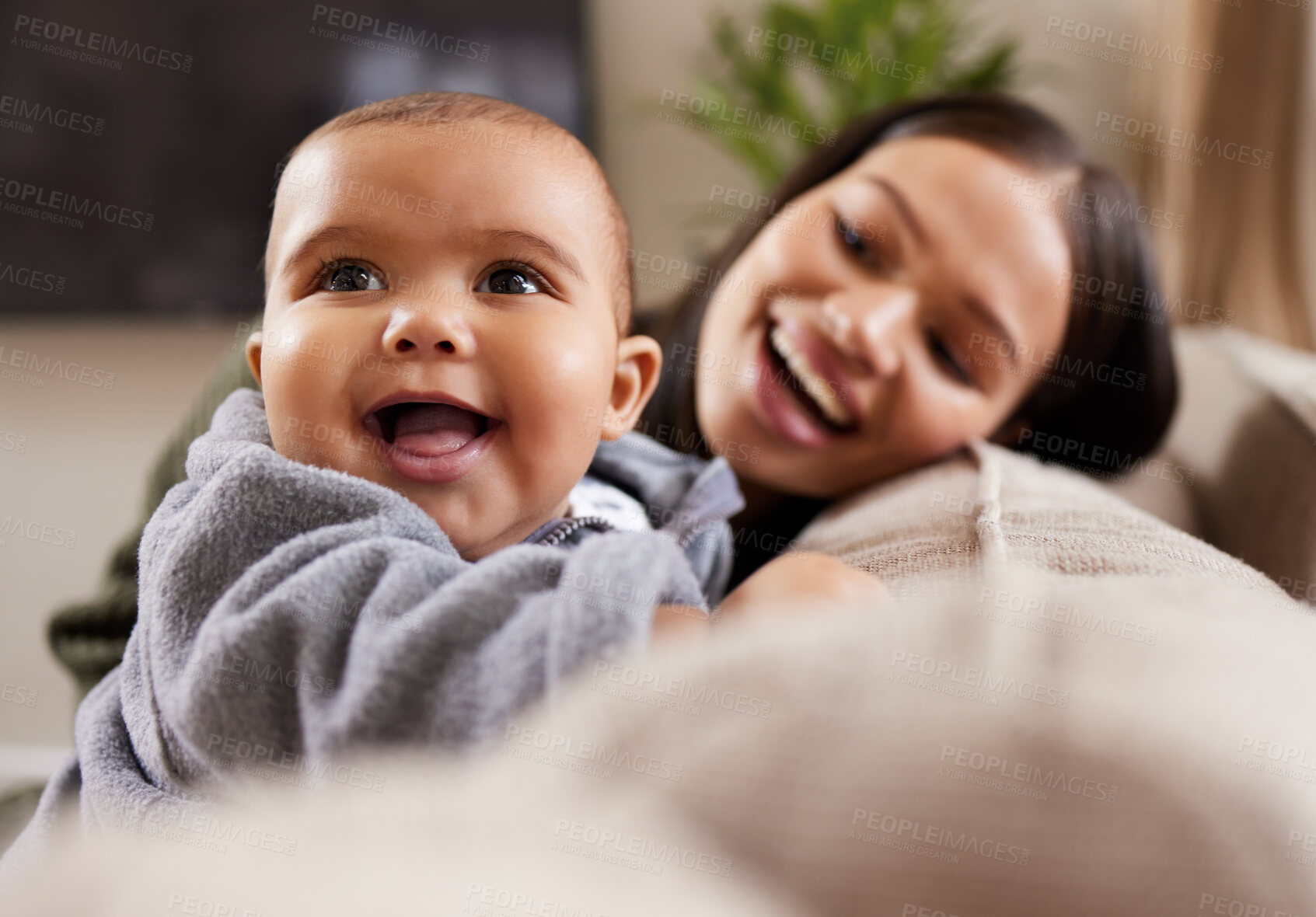 Buy stock photo Shot of a young woman relaxing with her adorable baby on the sofa at home