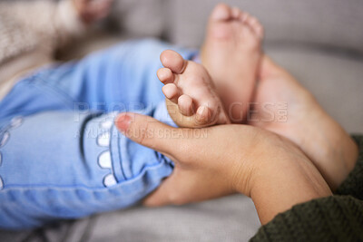 Buy stock photo Shot of an unrecognisable woman holding her baby’s feet  at home