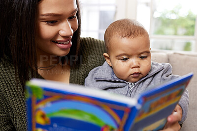 Buy stock photo Shot a mother reading a book to her baby at home