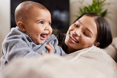 Buy stock photo Shot of a young woman relaxing with her adorable baby on the sofa at home