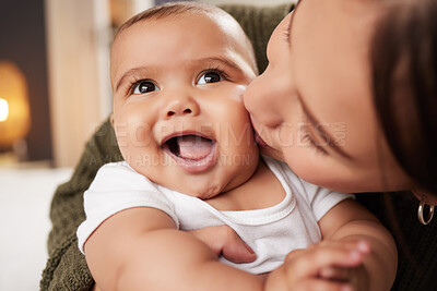 Buy stock photo Shot of a young woman carrying her baby at home