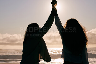 Buy stock photo Shot of two unrecognizable friends standing together and holding hands while bonding during a day out
