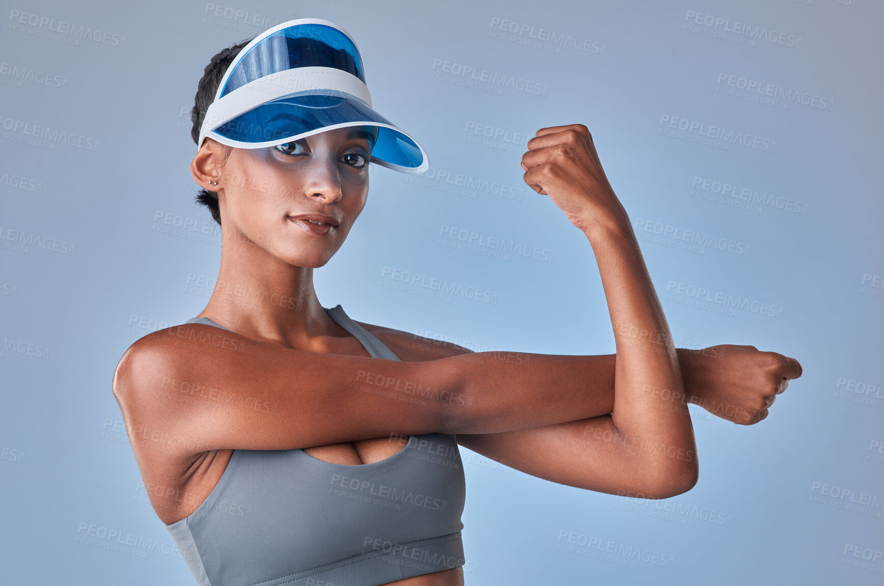 Buy stock photo Studio shot of a fit young woman stretching against a grey background