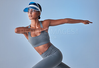 Buy stock photo Studio shot of a fit young woman stretching against a grey background