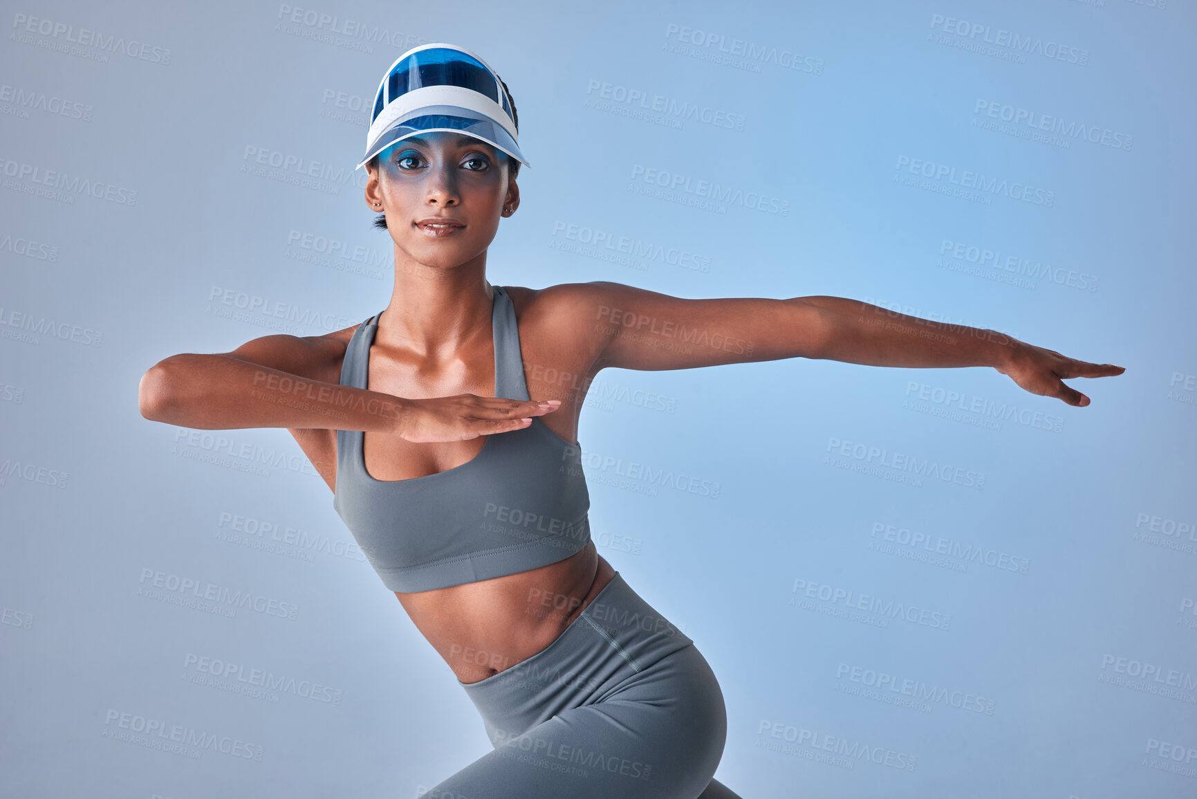 Buy stock photo Studio shot of a fit young woman stretching against a grey background