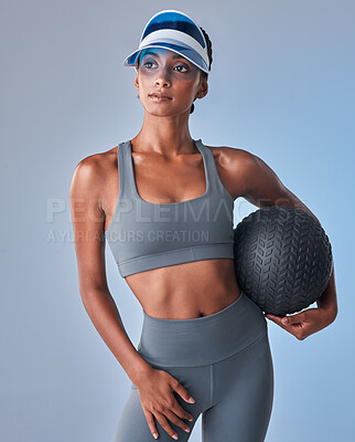 Buy stock photo Studio shot of a fit young woman working out with a medicine ball against a grey background