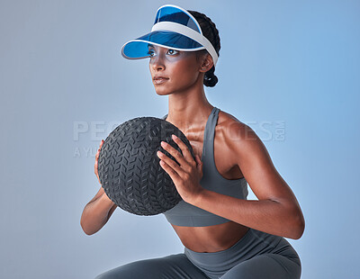 Buy stock photo Studio shot of a fit young woman working out with a medicine ball against a grey background