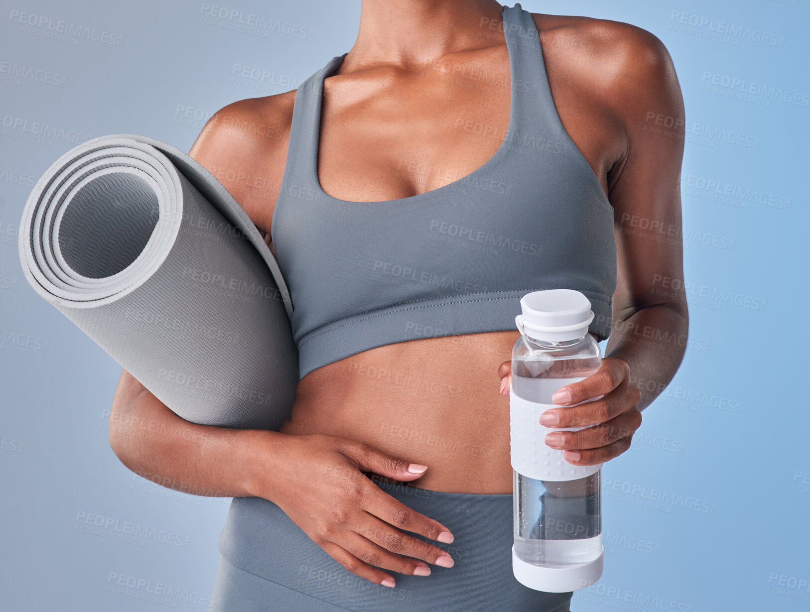 Buy stock photo Studio shot of a fit woman drinking bottled water against a grey background