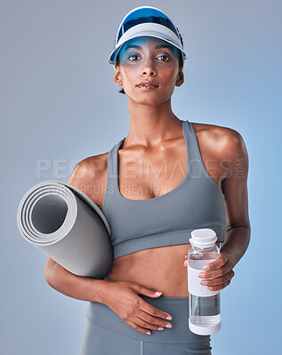 Buy stock photo Studio shot of a fit young woman drinking bottled water against a grey background