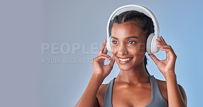 Buy stock photo Studio shot of a fit young woman using headphones against a grey background