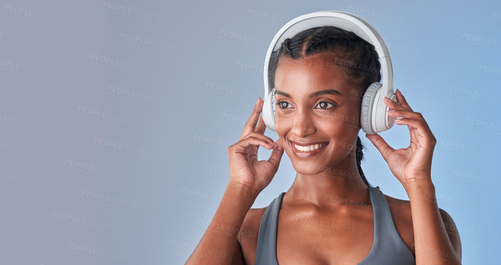 Buy stock photo Studio shot of a fit young woman using headphones against a grey background