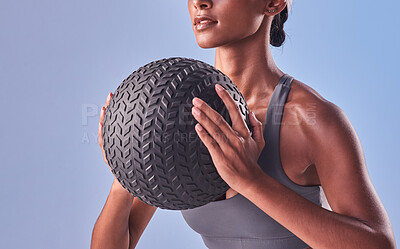 Buy stock photo Studio shot of a fit young woman working out with a medicine ball against a grey background