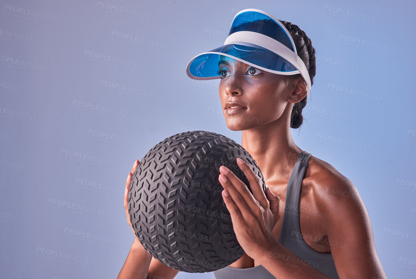 Buy stock photo Studio shot of a fit young woman working out with a medicine ball against a grey background