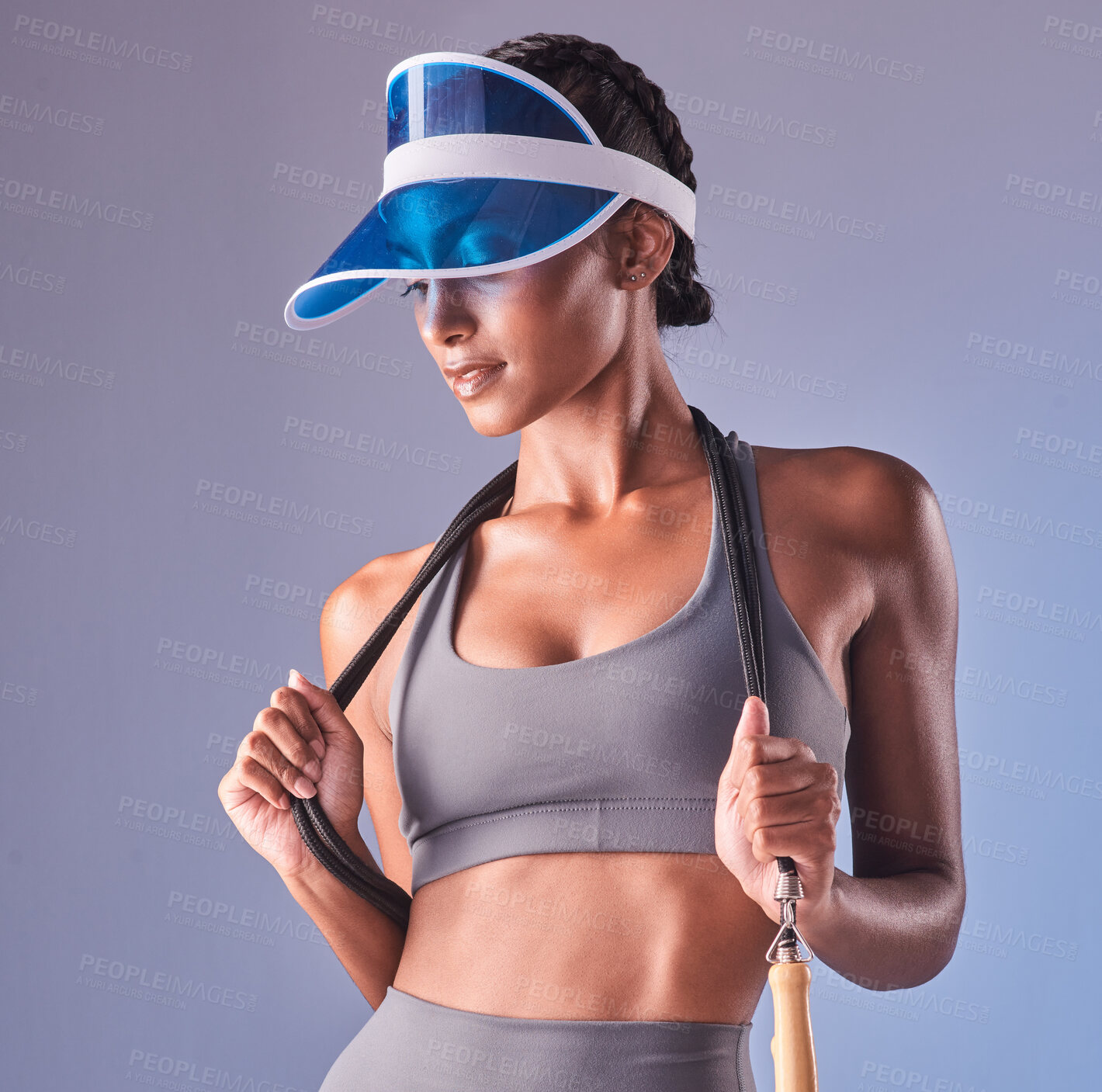 Buy stock photo Studio shot of a fit young woman working out with jump rope against a grey background