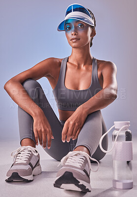 Buy stock photo Studio shot of a fit young woman drinking bottled water against a grey background