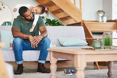 Buy stock photo Shot of a father and his little daughter relaxing together at home