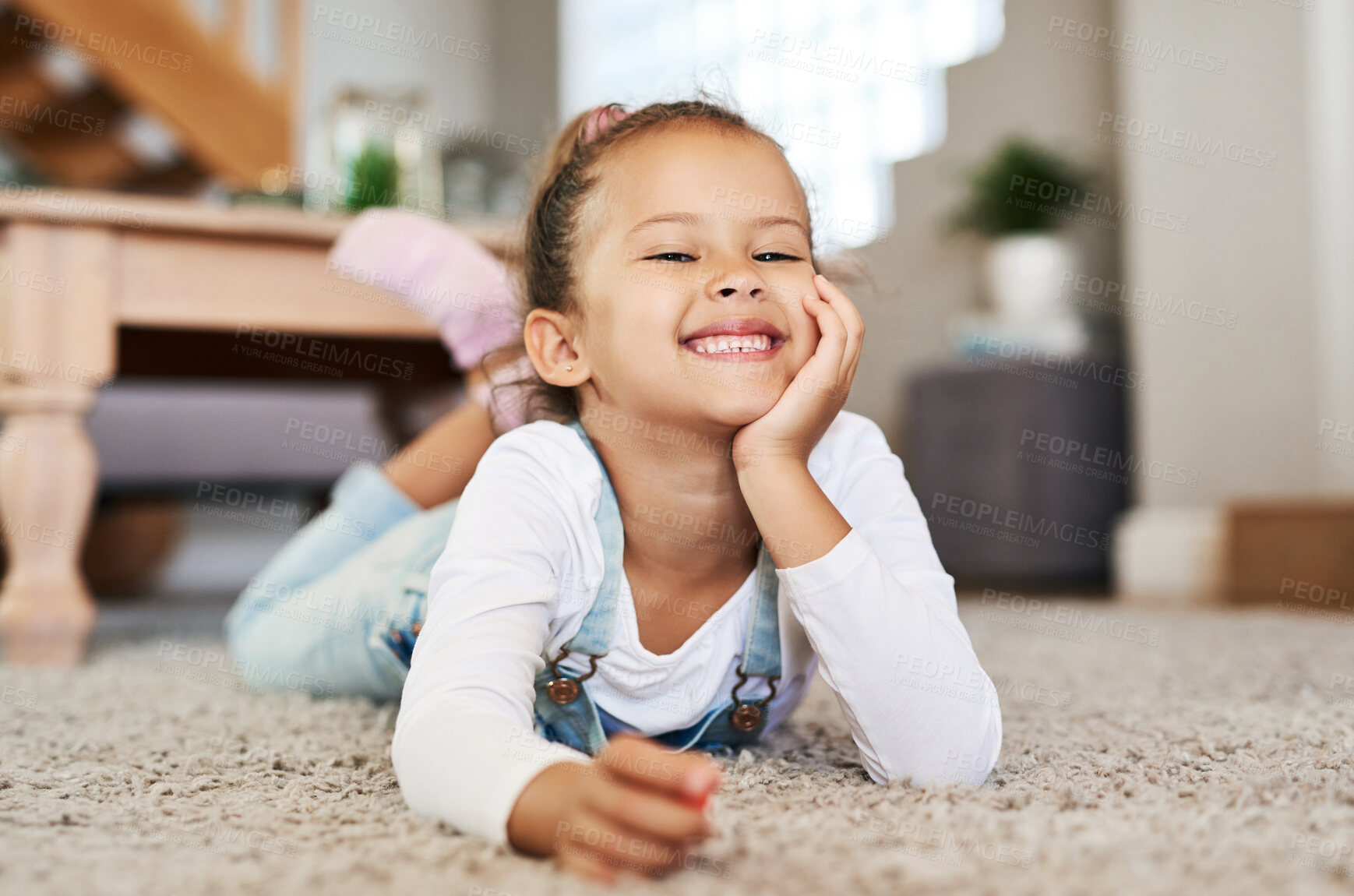 Buy stock photo Portrait of an adorable little girl lying on the floor at home