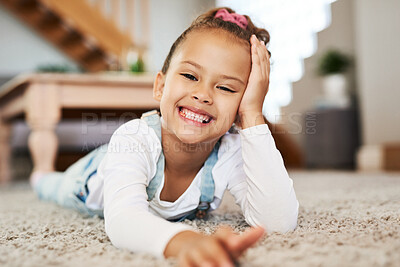 Buy stock photo Portrait of an adorable little girl lying on the floor at home