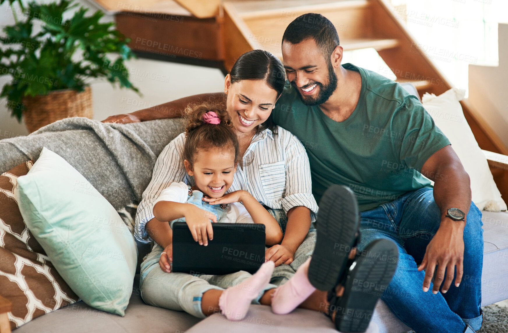 Buy stock photo Shot of a happy family using a digital tablet together at home