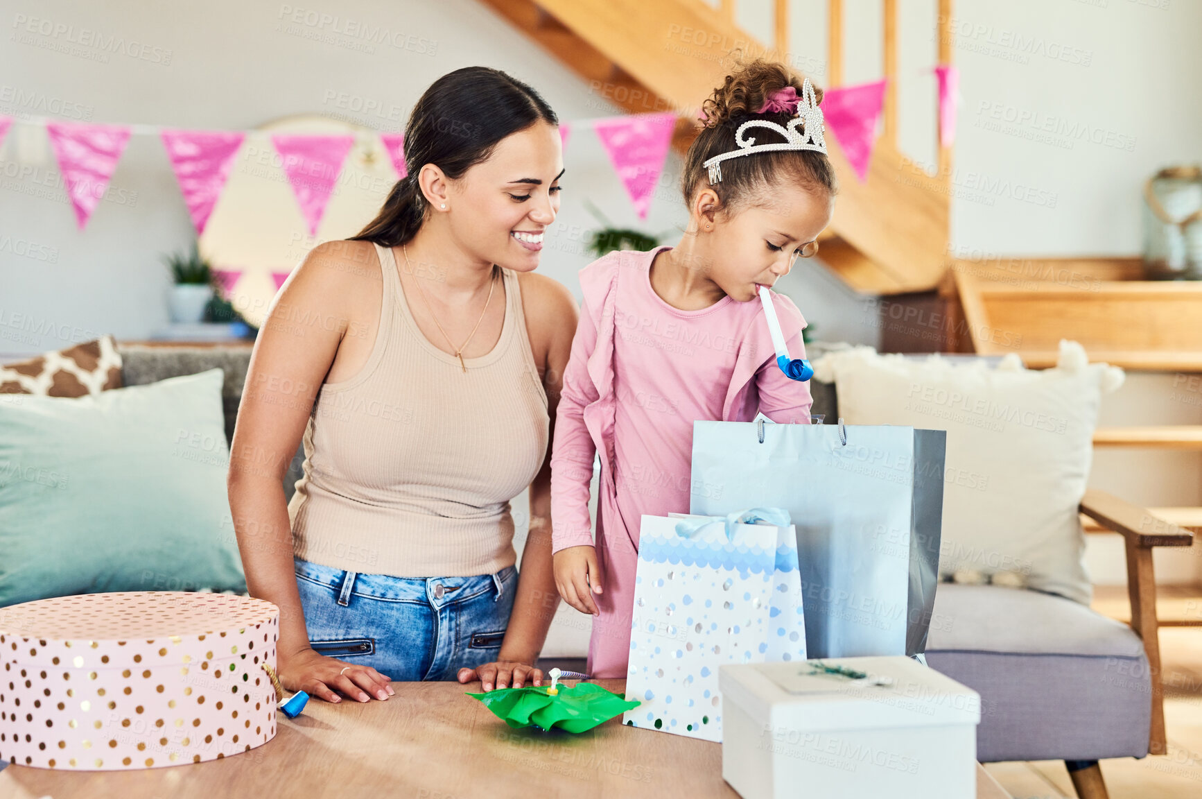 Buy stock photo Shot of a little girl opening her presents during a birthday party at home