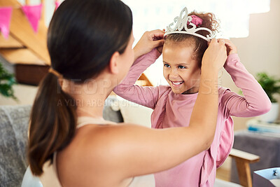 Buy stock photo Shot of a mother putting a crown on her daughter's head during her birthday at home