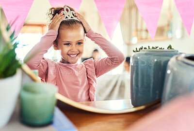 Buy stock photo Shot of a little girl putting on a crown in the mirror at home