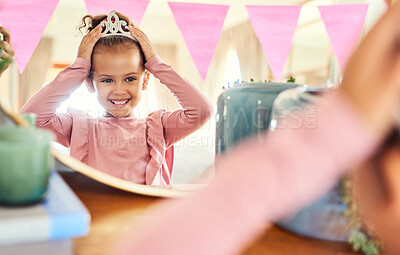 Buy stock photo Shot of a little girl putting on a crown in the mirror at home