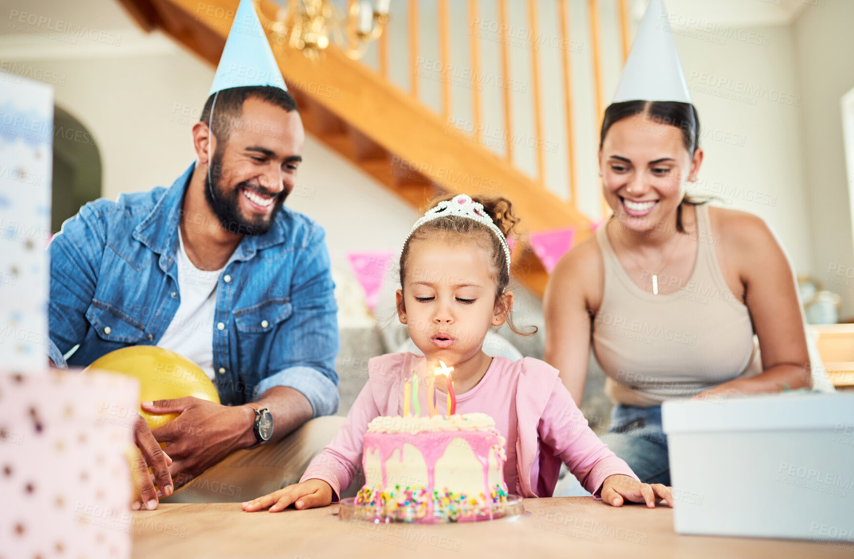 Buy stock photo Shot of a little girl celebrating a birthday with her parents at home