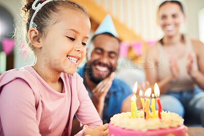 Buy stock photo Shot of a little girl celebrating a birthday with her parents at home