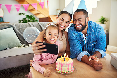 Buy stock photo Shot of a young mother taking a selfie at her daughter's birthday celebration at home