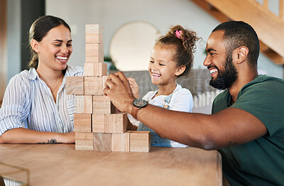 Buy stock photo Shot of a happy family playing with wooden blocks together at home