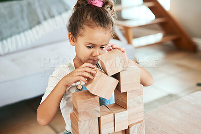 Buy stock photo Shot of an adorable little girl playing with wooden blocks at home