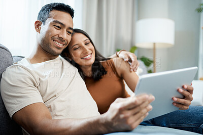 Buy stock photo Happy couple, tablet and relax on sofa for online streaming, entertainment or social media at home. Man and woman sitting in living room with smile for technology, connection or networking at house