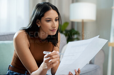 Buy stock photo Woman, documents and reading on sofa for finance, expenses or checking bills in living room at home. Face of female person with paperwork in budget planning, investments or financial plan at house
