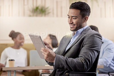 Buy stock photo Shot of a young businessman using his digital tablet while at work