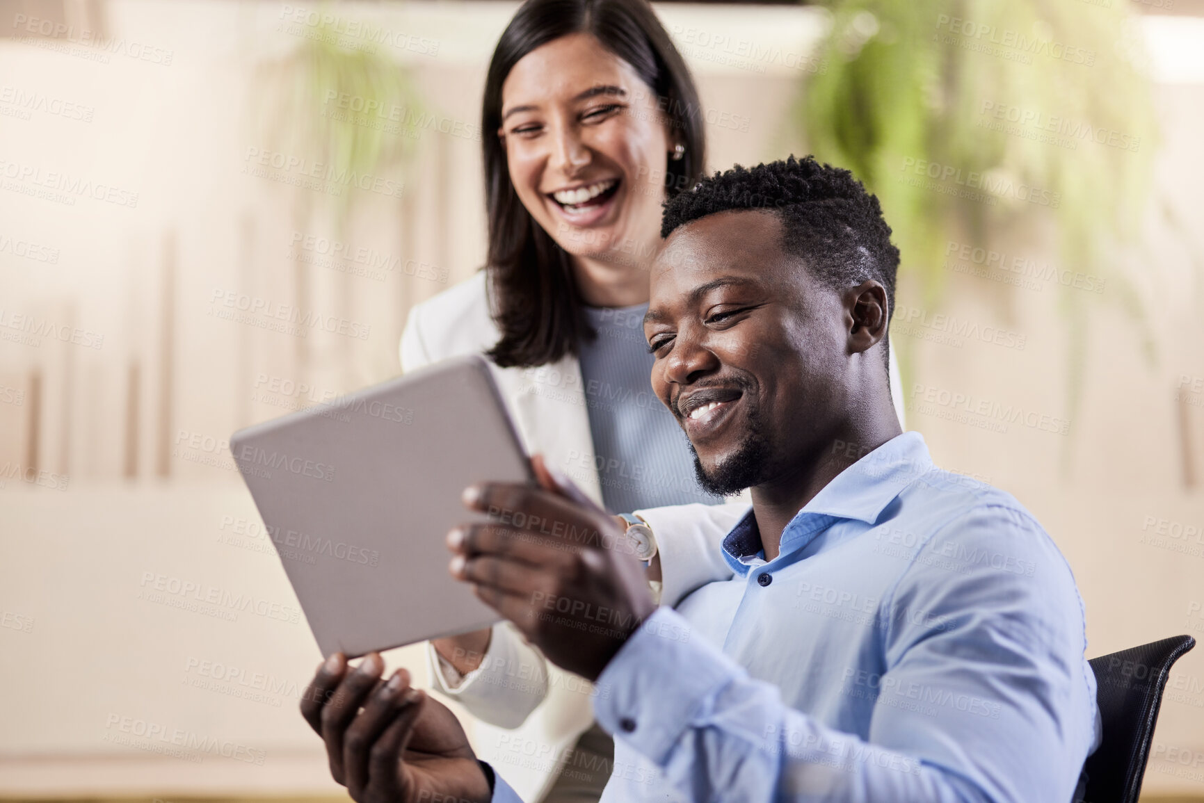 Buy stock photo Shot of two coworkers using a digital tablet together