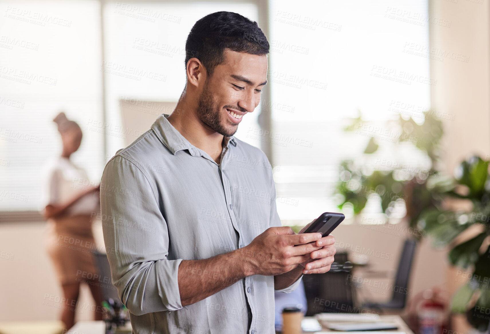 Buy stock photo Shot of a young businessman using his smartphone to send a text message