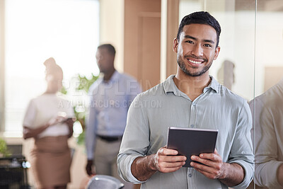 Buy stock photo Shot of a young businessman using his digital tablet at work